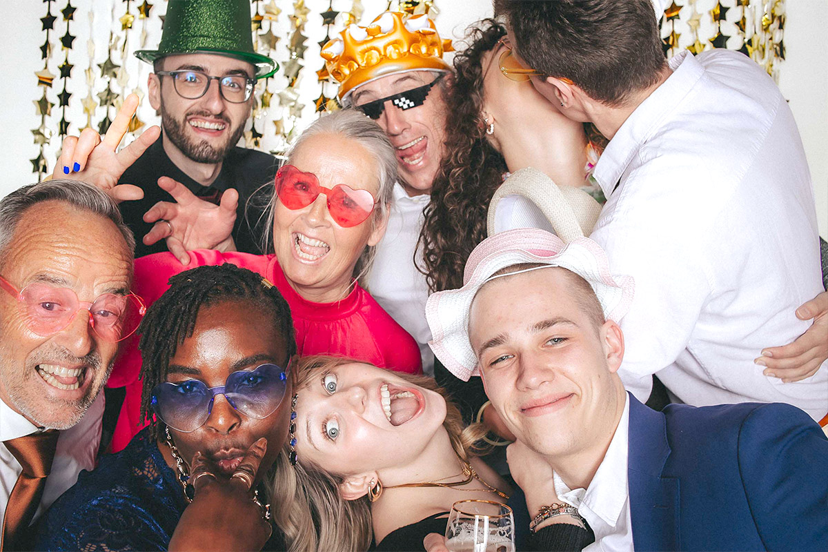 Lachende Gruppe macht Foto mit Fotobox